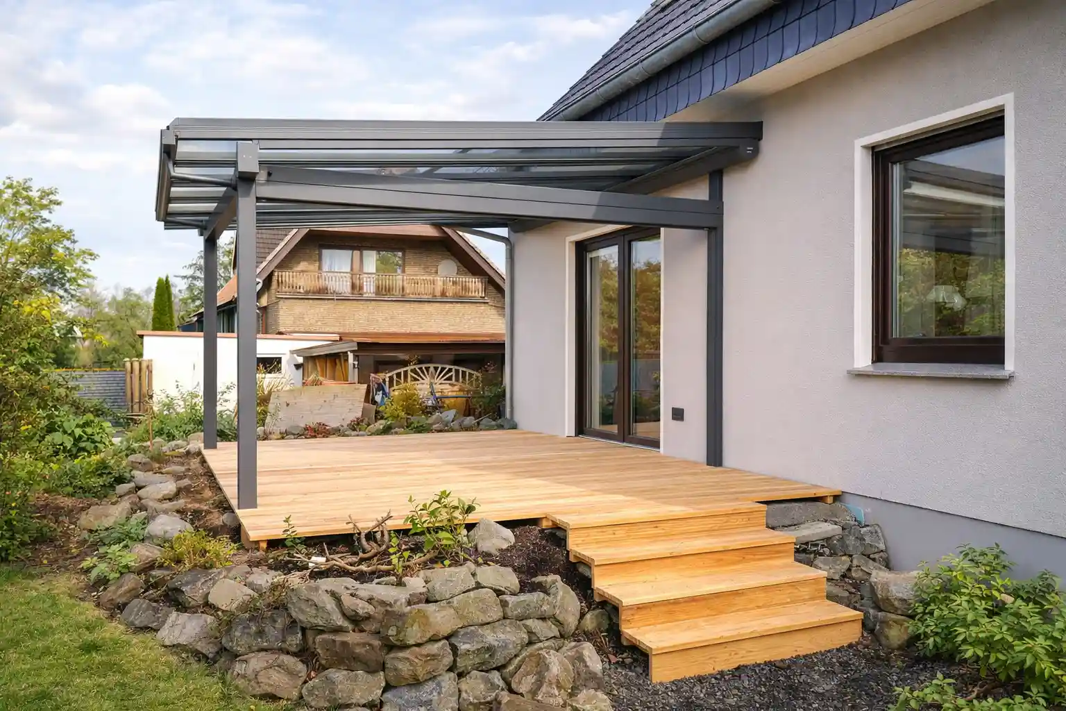 Holzterrasse mit Wintergarten
