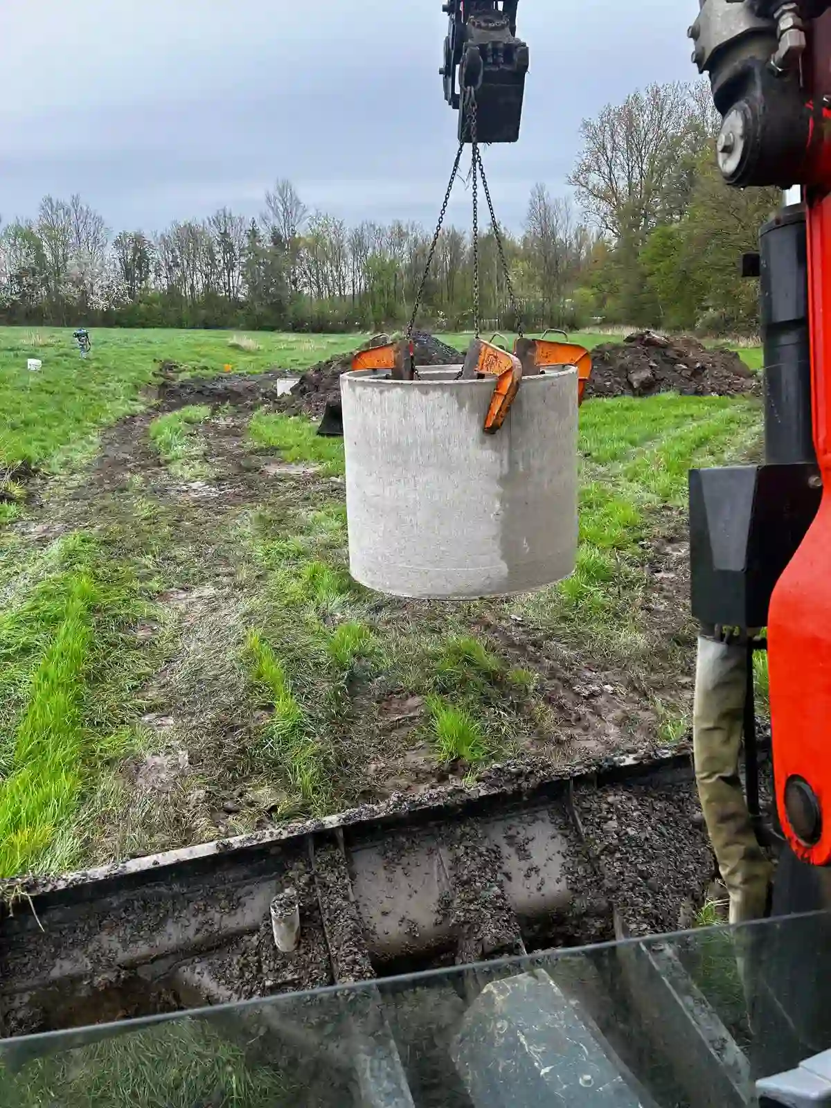 Einsetzen eines Schachtrings durch einen Bagger