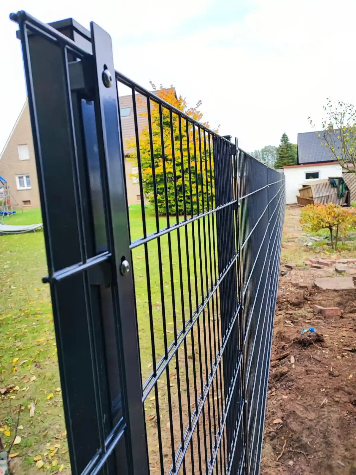 Installation eines schwarzen Metallgitter-Zauns